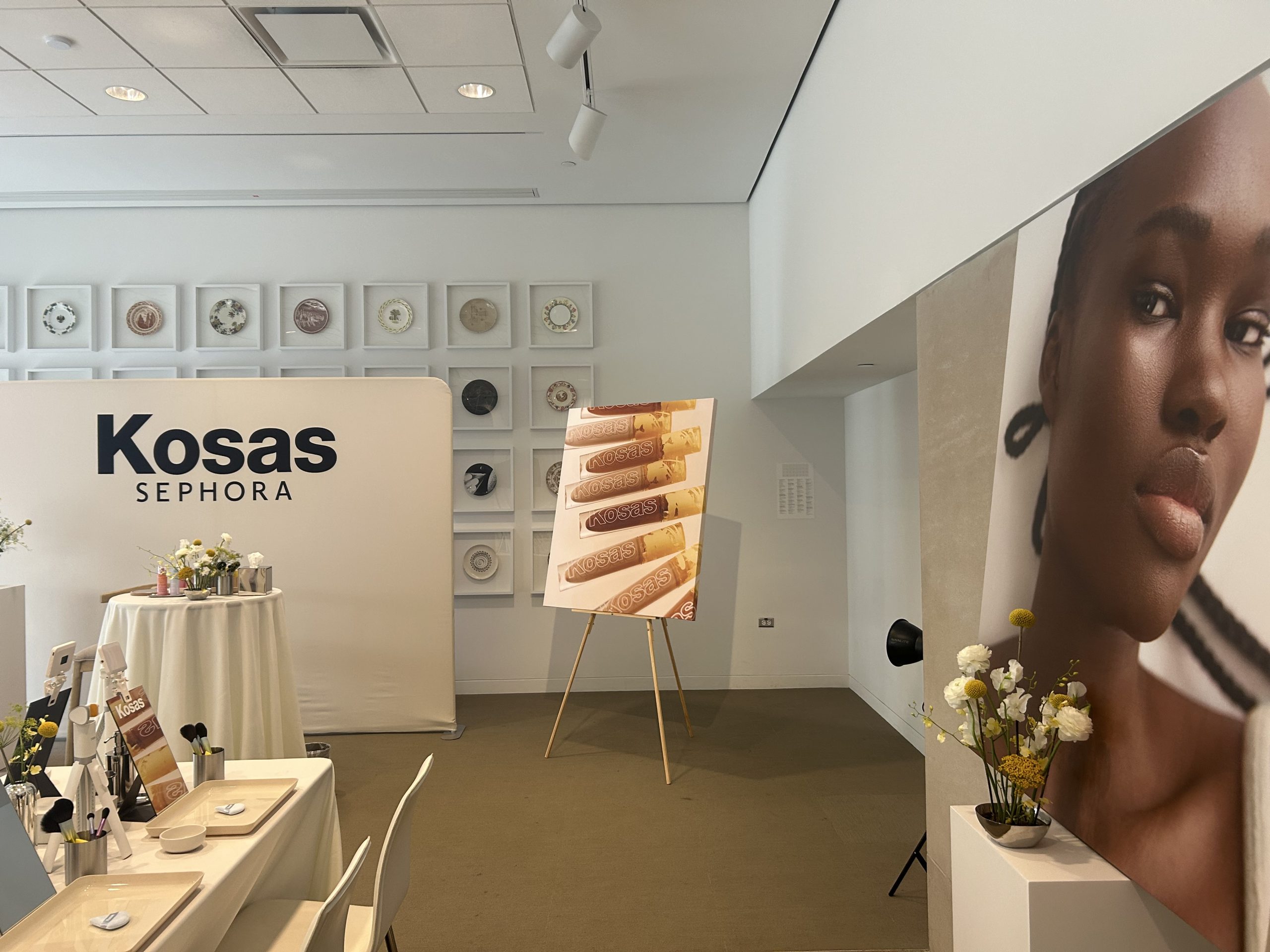 Kosas and Sephora fabric backdrop beside large canvas campaign imagery and makeup stations.