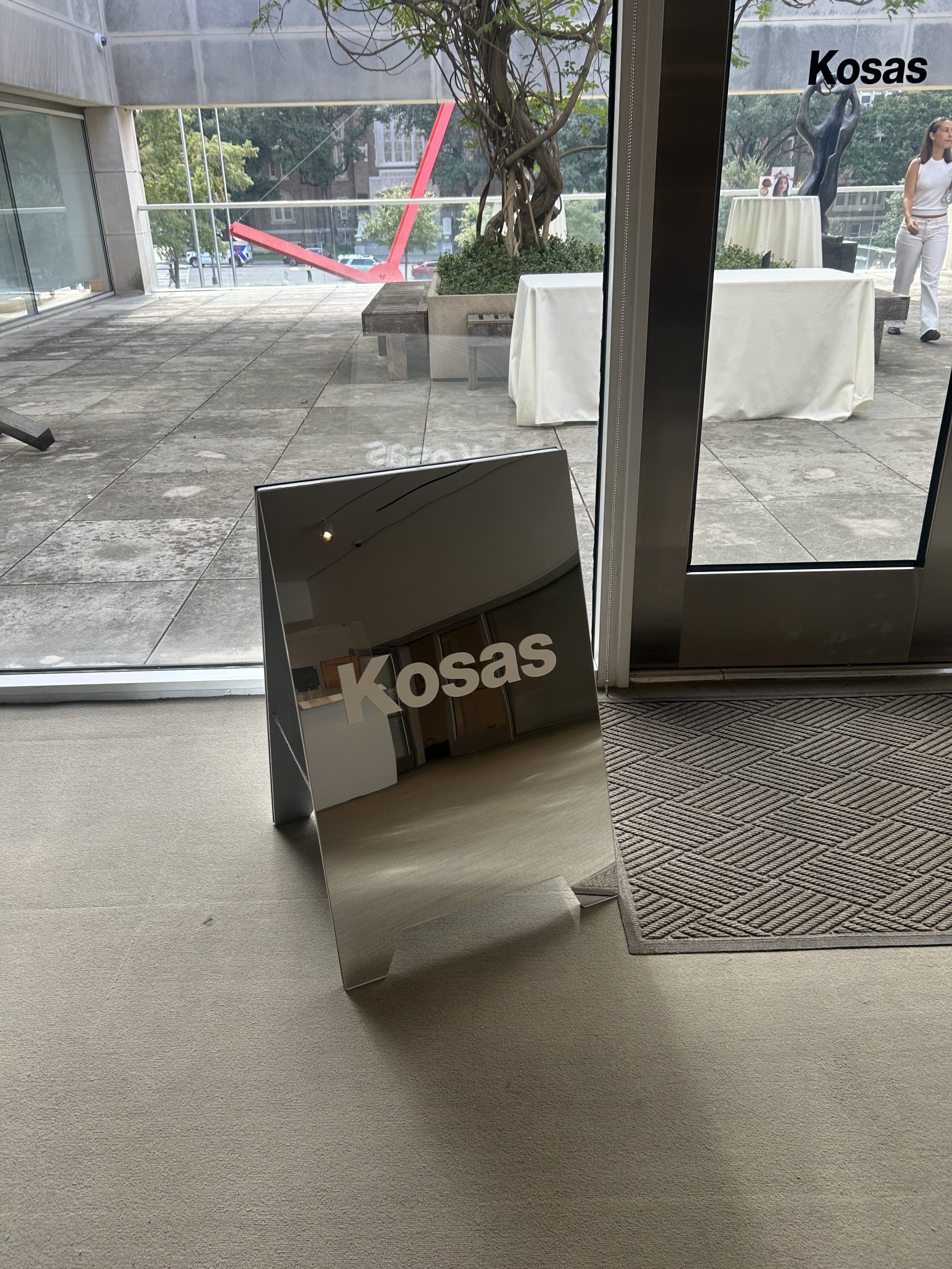 White Kosas logo on a freestanding mirror with black Kosas lettering on the glass beyond.